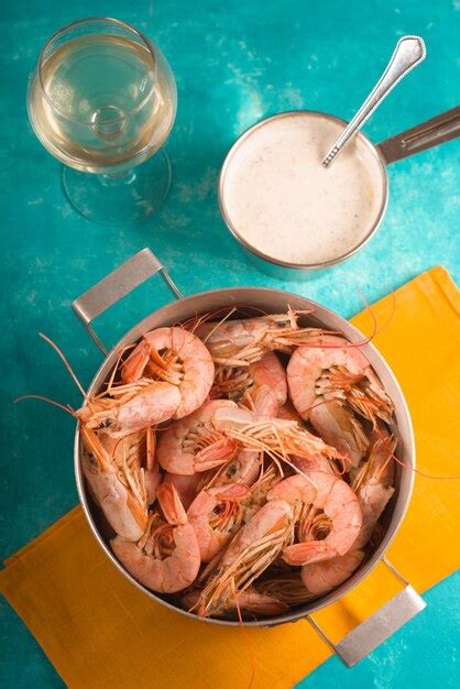 Des crevettes sur un verre de serviette jaune avec du vin blanc et de la sauce verticale | Photo ...