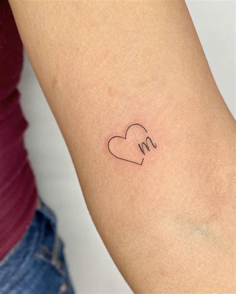 Heart and letter "M" tattoo located on the inner arm.