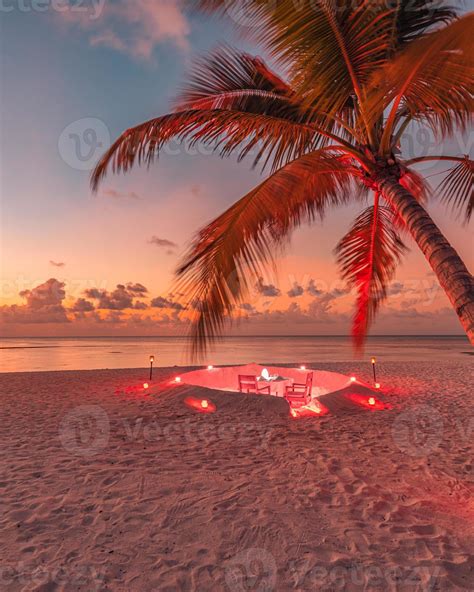 Romantic dinner on the beach with sunset, candles with palm leaves and ...