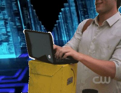 a man standing in front of a yellow box with a laptop on it's lap