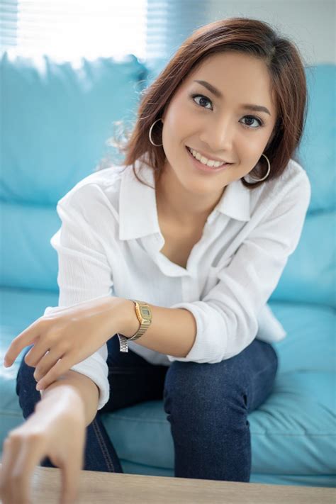 Mulheres asiáticas sorrindo felizes para relaxar no sofá em casa [download] - Designi
