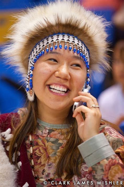 Young Yup'ik woman with tradtional headdress talks on cell phone at the World Eskimo and Indian ...