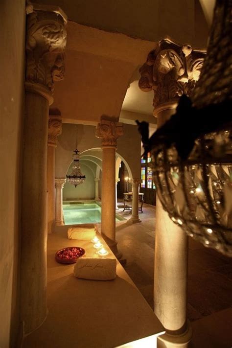 an indoor swimming pool with columns and lights