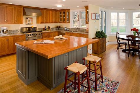 Combination of cherry and blue painted custom kitchen cabinetry with a cherry island top and ...