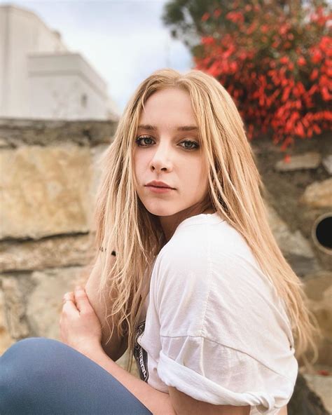 a woman with long blonde hair sitting on the ground