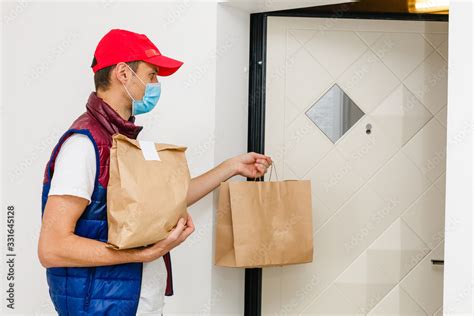 Delivery man holding paper bag with food on white background, food ...