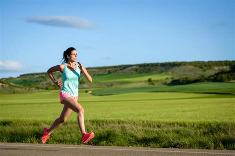 Sporty woman running fast on country side road. Female athlete training outdoor. - Half Marathon ...