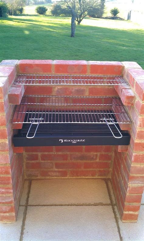 an outdoor brick oven with the door open and grilling racks on it's sides