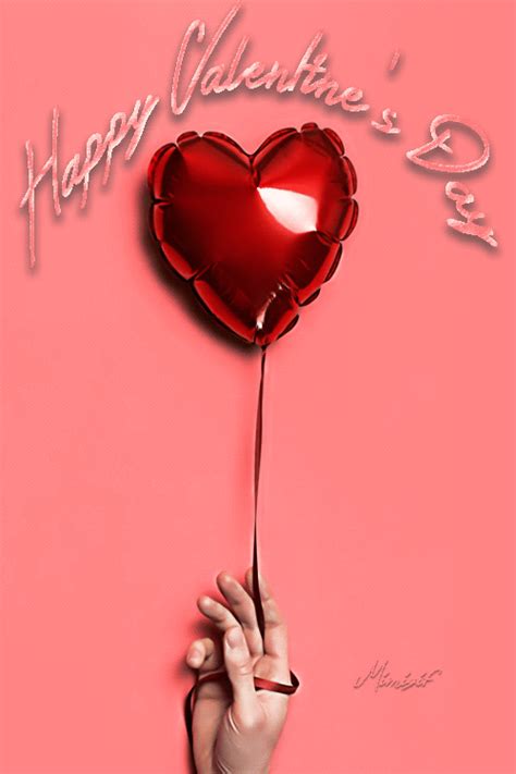 a hand holding a heart shaped balloon with the words happy valentine's day on it