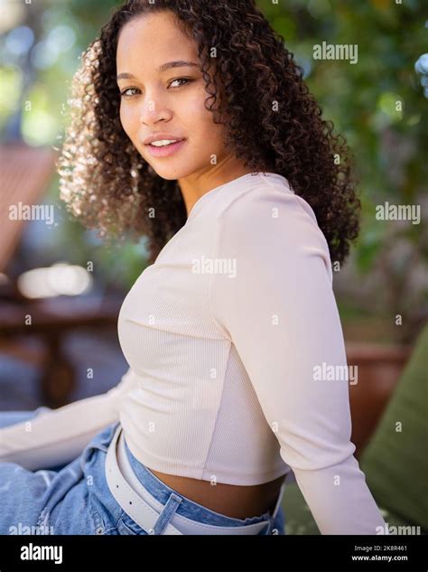 Young Happy Multiracial Woman Sitting on Patio Lounge Chair Stock Photo - Alamy