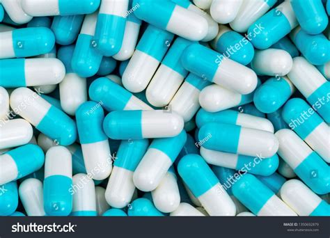 Top view pile of blue and white antibiotic capsule pills texture. Pharmaceutical production ...