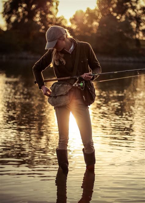 a woman standing in the water while fishing