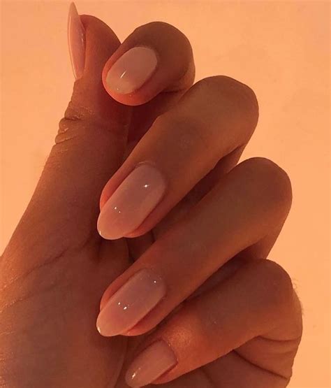 a woman's hand with some pink nail polish on it