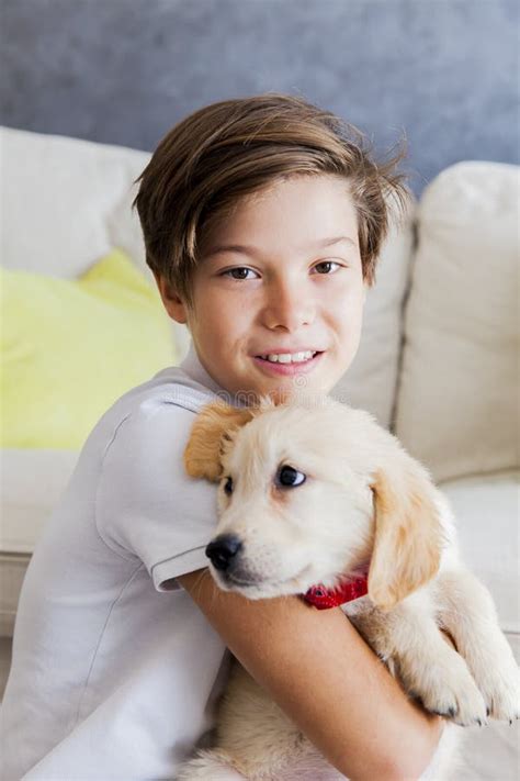 Cute Teen Boy with Baby Retriever Dog in Room Stock Photo - Image of ...