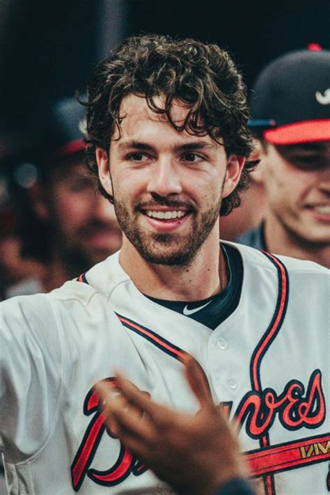 a baseball player is smiling and holding his hand out in the air with ...