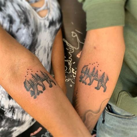 two people with matching tattoos on their arms