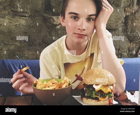 Boy Eating French Fries And Burger At Restaurant Stock Photo - Alamy