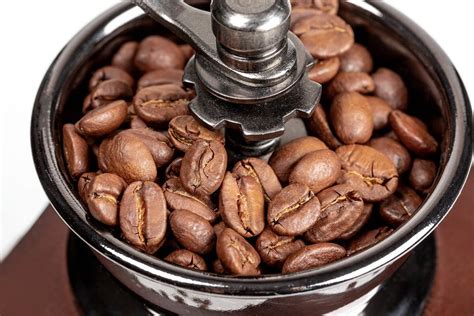 Roasted coffee beans in a mechanical coffee grinder, close-up ...
