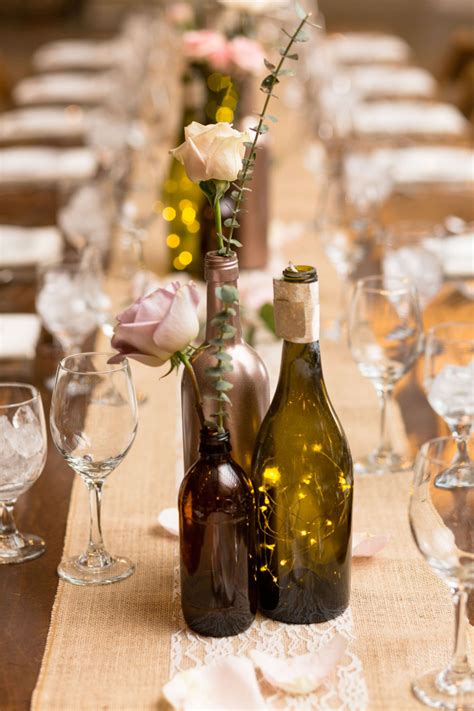 Wine bottle centerpieces on farm tables by Little Miss Lovely // Ocean City, MD wedding florist ...