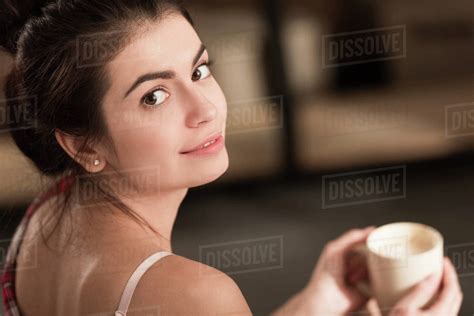 Selective focus of beautiful girl drinking coffee in the morning - Stock Photo - Dissolve