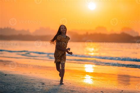 Adorable happy little girl on white beach at sunset. 17749982 Stock Photo at Vecteezy