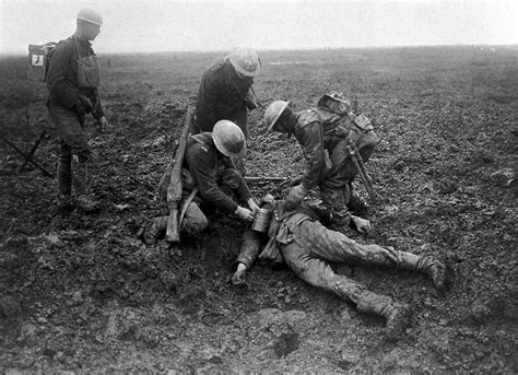 Canadian soldiers tend to a fallen German on the battlefield at the Battle of Vimy Ridge in 1917 ...