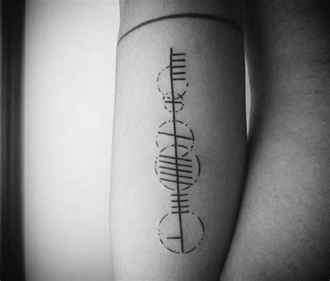 Ogham tattoo on the arm reading "Herman"