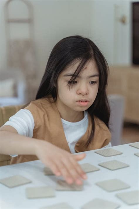 Small Girl Sitting at Table Playing Game · Free Stock Photo
