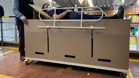 The cardboard hospital bed becomes a coffin: practical, but not reassuring