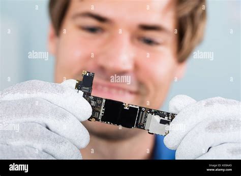 Close-up Of A Happy Man Holding Smart Phone Circuit Board Wearing Glove Stock Photo - Alamy
