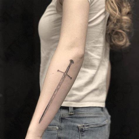 Sword tattoo on the left forearm.