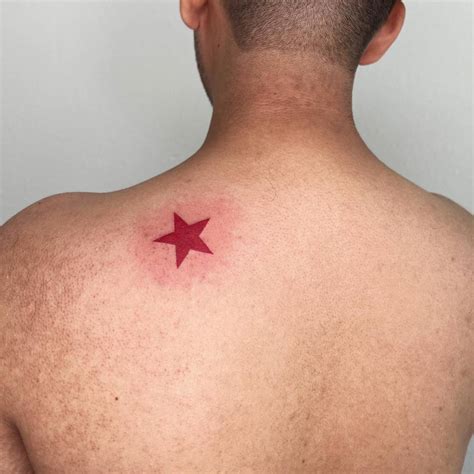 Minimalistic red star tattoo placed on the shoulder