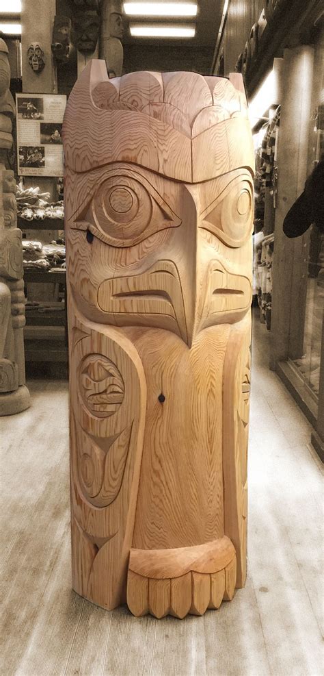 a wooden totem sitting on top of a hard wood floor in a store next to shelves