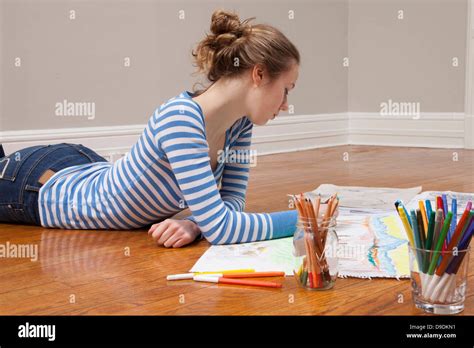 Girl lying on floor drawing picture Stock Photo - Alamy