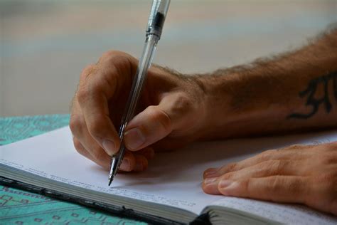 Man Writing in a Book · Free Stock Photo