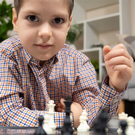 Premium Photo | Little boy playing chess board games for children