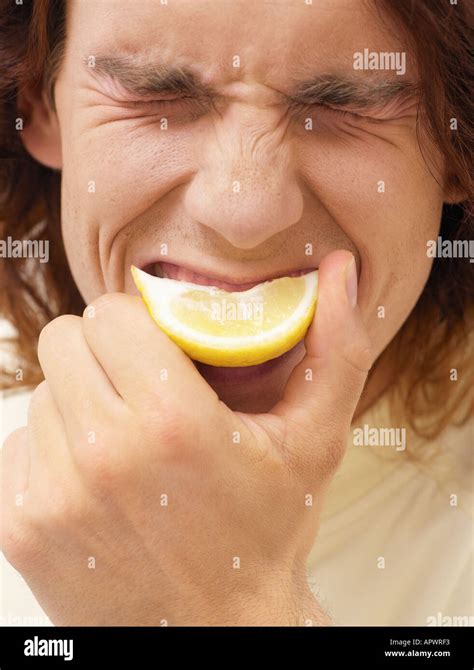 Man biting a slice of lemon Stock Photo - Alamy