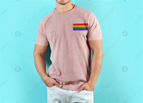 Young man wearing pink t-shirt with image of LGBT pride flag on turquoise background: Stock ...