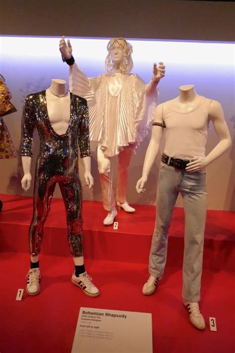 three mannequins are on display in front of a red carpeted floor