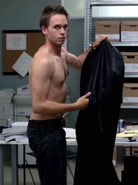 a shirtless man is holding a black jacket