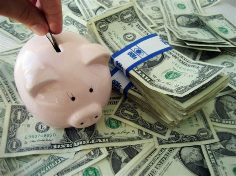 File:Putting money into a piggybank.jpg - Wikimedia Commons