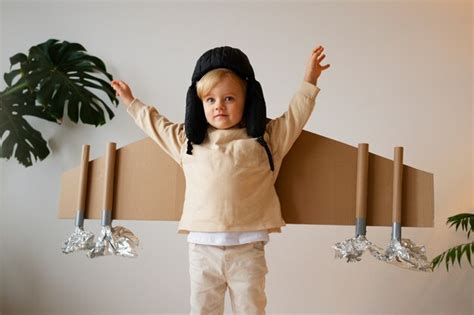 Premium Photo | Front view boy playing with cardboard wings