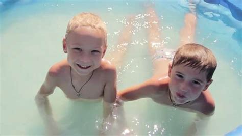 Two little boys in the pool and splash water at each other - Stock ...