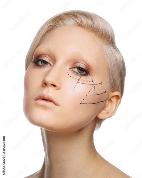 Pretty fashionable white blonde girl with perforation lines on face, plastic surgery concept ...
