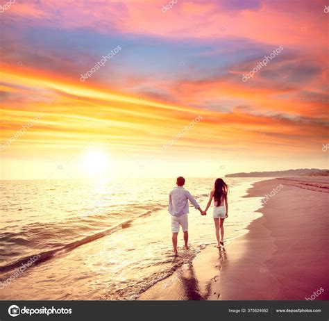 Young Couple Walking Beach Sunset Stock Photo by ©tomwang 375624682