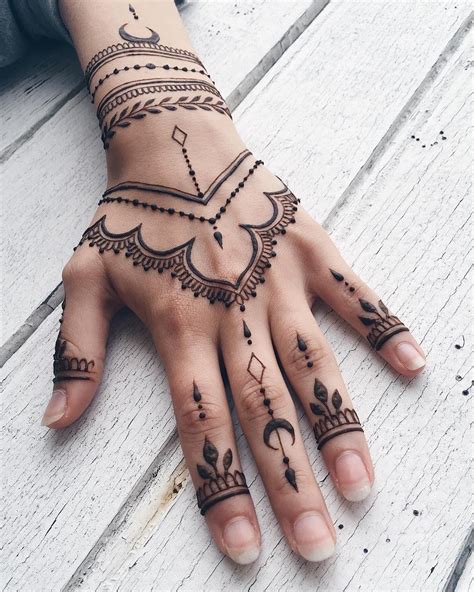 a woman's hand with henna tattoos on it
