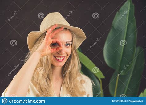 White Blonde Woman in Sun Hat Looking through Fingers into Camera with Wide Smile. Perfect ...