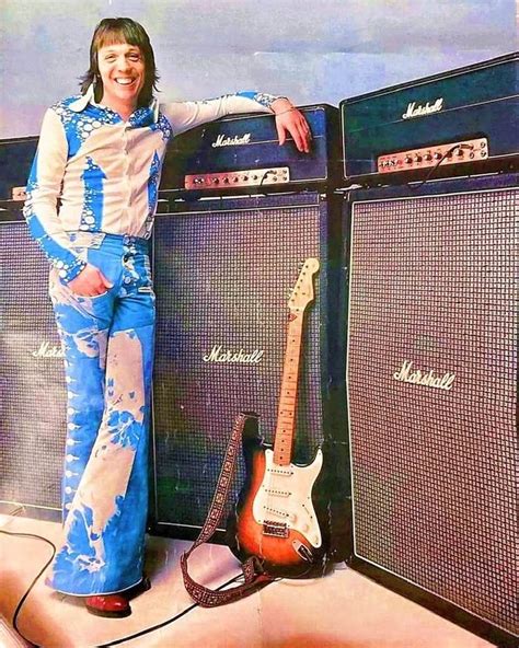 a woman standing next to some guitars and amps