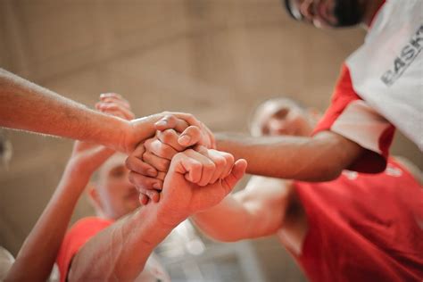 Basketball team stacking hands together · Free Stock Photo