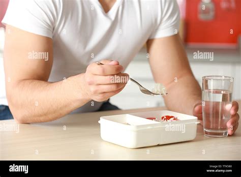 Man eating salad in the kitchen Stock Photo - Alamy